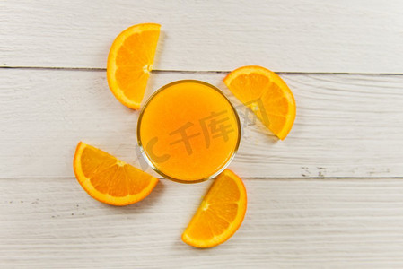 橙汁在玻璃和新鲜的橘子水果片在木桌