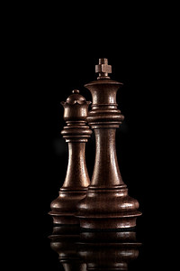 象棋概念黑木国王和王后，黑暗背景下最有权势的人物站在一起。