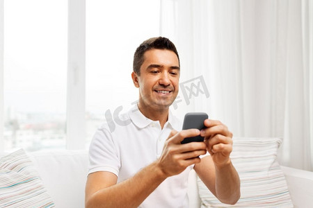 技术、人和沟通理念--家里有智能手机的快乐男人。家里有智能手机的快乐男士