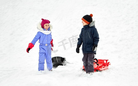 童年，雪橇和季节概念—快乐的小孩子与雪橇在冬天。快乐的小孩子与雪橇在冬天