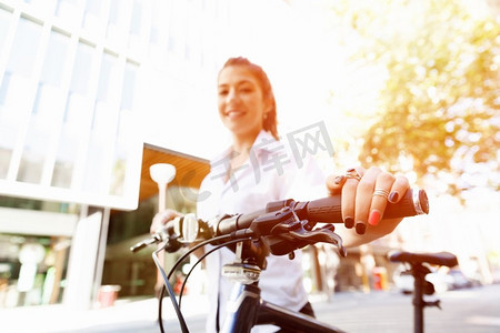 快乐的年轻女自行车手的肖像。快乐的年轻女骑车人在城市里骑行的肖像