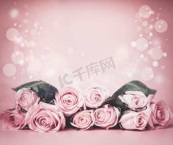 粉红色浅花卉背景与玫瑰束在桌上与bokeh.节日问候布局或婚礼概念