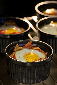 菜单早餐杯烤箱中的培根鸡蛋