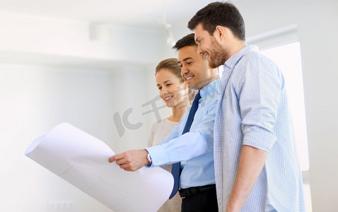 房贷、人和房地产概念-房地产经纪人向幸福夫妇展示新家的蓝图。房地产经纪人向新人展示新居蓝图