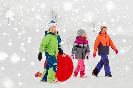 童年，雪橇和季节概念—一群快乐的小孩子在冬天户外雪橇。快乐的小孩子与户外在冬天