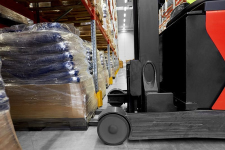 物流业务和装运概念—叉车装载货物在仓库的特写镜头。在仓库装载货物的叉车特写镜头