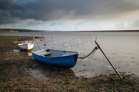 舰队摄影照片_停泊在舰队泻湖的小船美丽的日落风景图象在英国多塞特郡