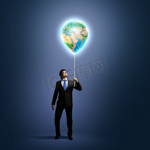 |生态理念。戴着护目镜的商人拿着地球仪的形象。保护地球。这张图片的要素由美国宇航局提供