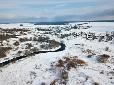 冬季乡村风光。村庄和田野被白雪覆盖。鸟瞰小河弯道