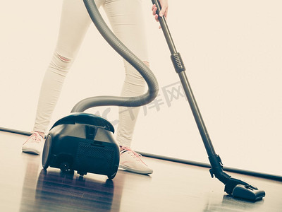 家庭清洁工具和器具，家政职责概念。女人的腿和吸尘器。女人的腿和吸尘器