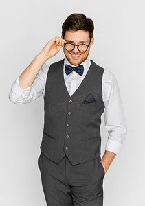 时尚、风格和复古概念-穿着节日服装、戴着眼镜的快乐男人。穿着节日套装戴着眼镜的快乐男士