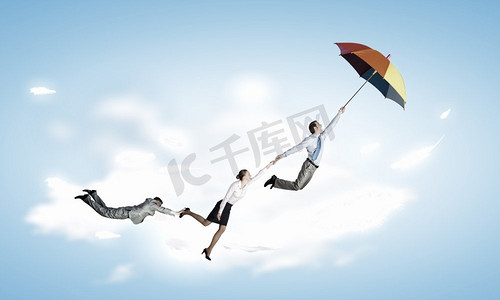 逃离办公室。商务人士撑着伞在天空中飞翔
