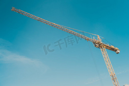 建筑工地建筑起重机在晚上清楚的蓝天背景。工业物体概念鹤对蓝天。