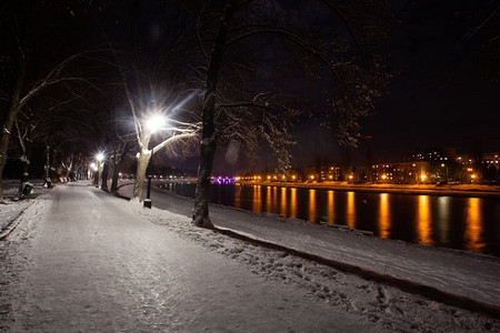 冷行人摄影照片_暮城雪堤。美丽的冬季景观。白雪皑皑的河堤夜景