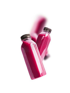 飞扬的紫色浆果奶昔或果汁瓶，白色背景。品牌文案空间