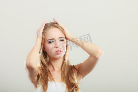 偏头痛摄影照片_头痛、偏头痛和压力。忧心忡忡的女性头痛不已