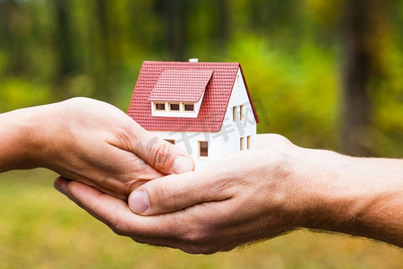 房屋模型在手中。购房贷款的概念。梦想着拥有属于自己的住所。家是你的家