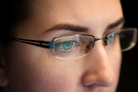 教育摄影照片_视觉，商业和教育概念—关闭妇女眼睛在眼镜看计算机屏幕特写在眼镜的妇女看屏幕
