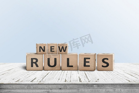 新的规则标志由木材在一个房间的桌子上与蓝色背景