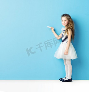 儿童跳芭蕾摄影照片_漂亮的小姑娘用粉笔写字