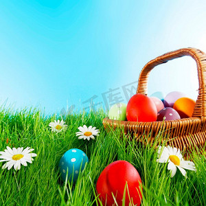 绿色草地上有彩蛋的复活节篮子，上面有花