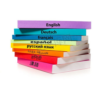 外语教育摄影照片_白色背景上隔开的一叠彩色书本。学习外语的概念。那堆五颜六色的书