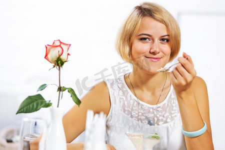咖啡馆里的可爱女孩。年轻漂亮女子坐在咖啡馆里吃甜点的肖像