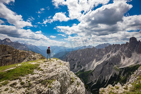 女徒步旅行者站起来达到顶峰。白云岩阿尔卑斯山中的国家自然公园。美丽的意大利自然风光。