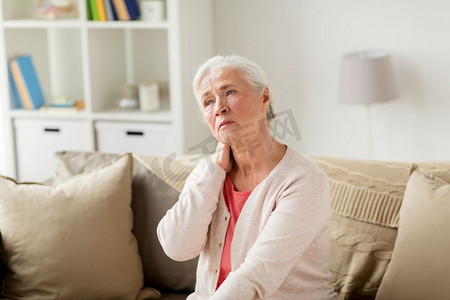 高龄女性摄影照片_老年，健康问题和人的概念-老年妇女在家中颈部疼痛。高龄女子在家中颈痛