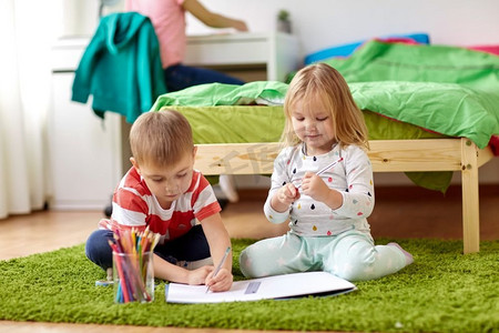 童年，休闲和人的概念快乐的孩子在家里画。快乐的孩子们在家中画画