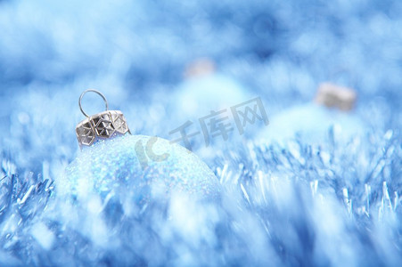 蓝色圣诞平安夜摄影照片_圣诞装饰品躺在闪闪发光的羽绒上。平安夜