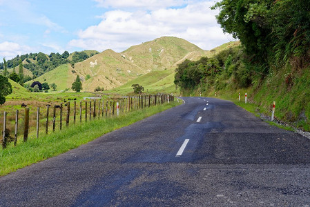 新西兰塔拉纳基被遗忘的世界公路。新西兰塔拉纳基穿过农田的寂寞风景公路