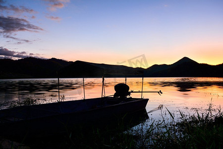风景日落河与渔船和黄色和蓝色天空黄昏美丽的剪影山背景