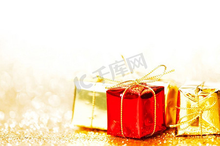 黄色背景框摄影照片_装饰红色和金色盒子与节日礼物在闪亮的闪光背景