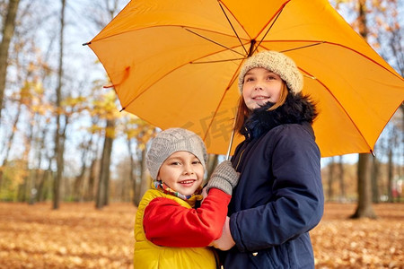 童年，季节和家庭概念—快乐的孩子与伞在秋天公园。快乐的孩子与伞在秋天公园