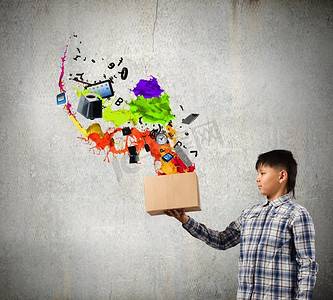 创造性思维。小男孩从纸箱里溅起五颜六色的油漆