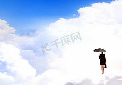 带伞的女人年轻女实业家与黑伞站立在云彩