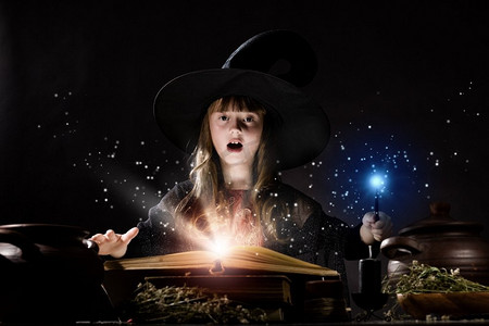 万圣节看书小孩摄影照片_万圣节女巫小万圣节女巫阅读变戏法从魔法书
