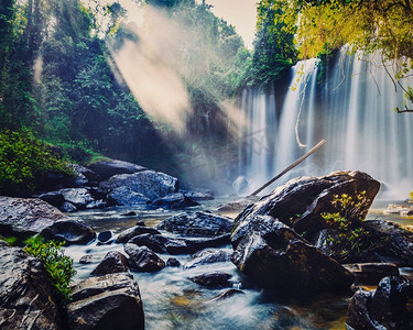 复古金边摄影照片_复古效果过滤了柬埔寨金库伦热带瀑布的潮人风格形象。柬埔寨的热带瀑布