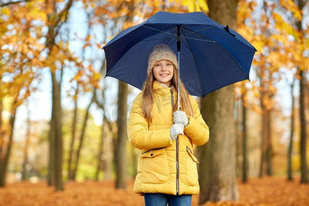 孩子伞摄影照片_季节和天气概念—愉快的女孩与伞在秋天公园。快乐的女孩与伞在秋天公园
