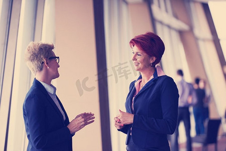 现代明亮办公室内两名企业女商人组队站立的肖像