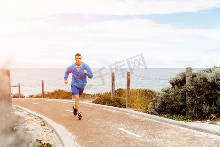 跑步运动的人摄影照片_健康的跑步者。健康的跑步的人在海滩上