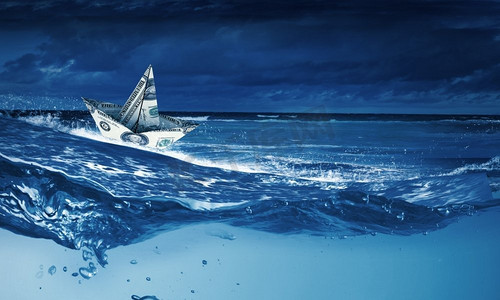 漂浮在水面上摄影照片_纸船。风浪中漂浮在水面上的纸船