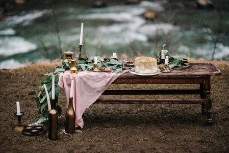 婚礼装饰，在瀑布的背景下，木凳上有一个金色的蛋糕