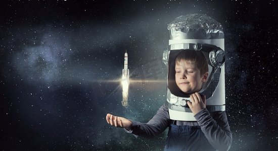 儿童宇宙摄影照片_我要探索太空。头戴纸盒头盔的可爱男孩梦想成为宇航员