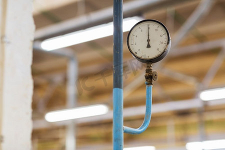 测量设备概念-工业工厂的老式气压计。工业厂房里的旧气压计