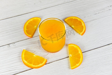 橙汁在玻璃和新鲜的橘子水果片在木桌 