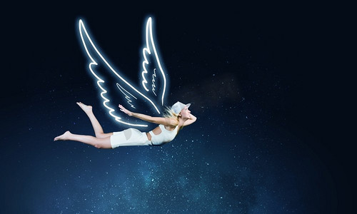 高端大气背景黑色摄影照片_天使女孩高飞可爱的女孩与天使画的翅膀在黑暗的天空背景