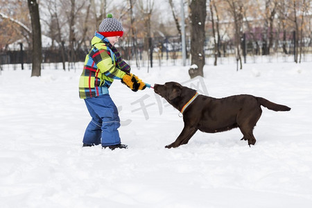 学龄儿童与狗在冬季公园。我和我最好的朋友