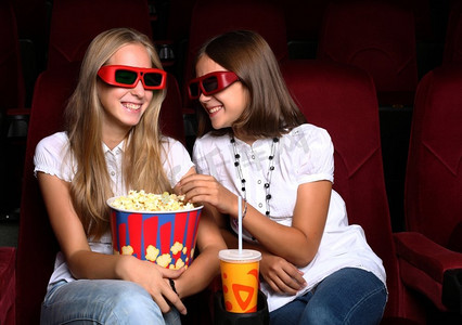 看电影摄影照片_两个年轻女孩在电影院看电影